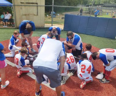Belonging \ Epidermolysis Bullosa News \ Jonah and his teammates pray on the baseball field before a game