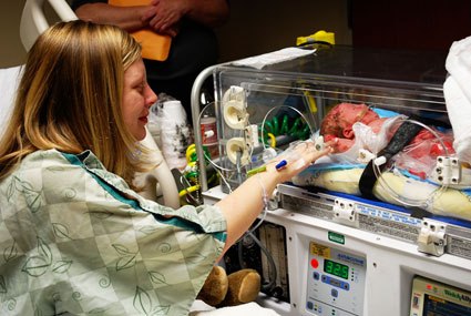 miracle | Epidermolysis Bullosa News Today | A 13-year-old photo shows Patrice in a hospital gown saying goodbye to her then newborn son Jonah, who is being prepared to be transported to another hospital's NICU