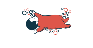 An infant in red pajamas is seen sleeping.