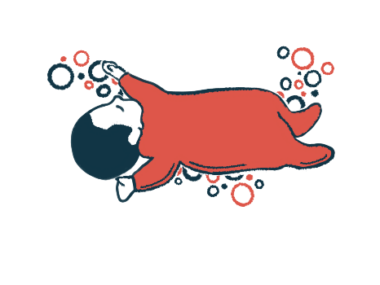 An infant in red pajamas is seen sleeping.