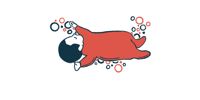 An infant in red pajamas is seen sleeping.